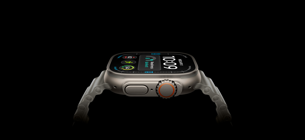 Apple Watch Ultra 4 med urkasse av naturlig titan og Ocean Band i gjennomskinnelig grå viser en digital urskive på skjermen. På høyre side av urkassen vises Digital Crown og den hevede sideknappen.