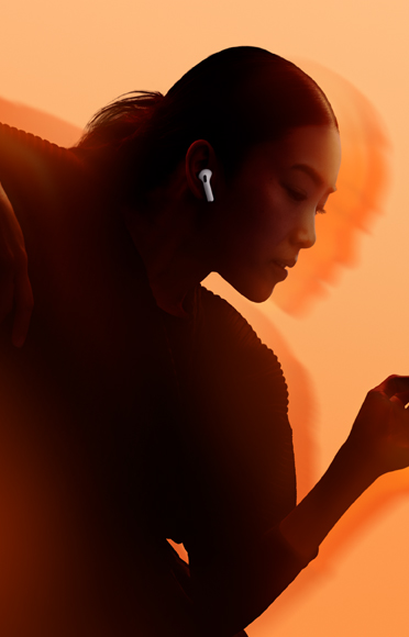 Una persona con unos AirPods 5, codos flexionados, fondo multicolor