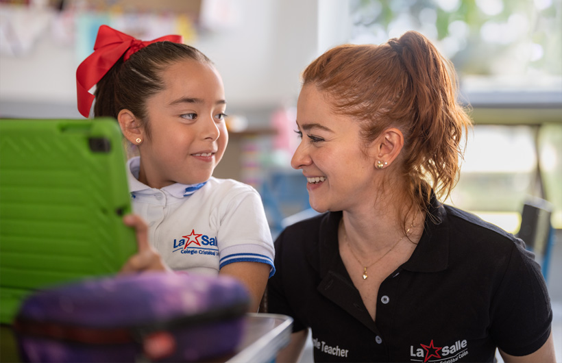 Eleane Ruth Guzmán Padilla y una de sus alumnas en una sala de clases del Colegio Cristóbal Colón.