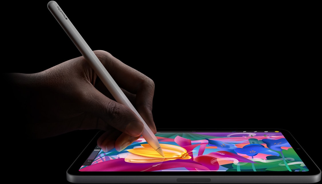 En hånd holder Apple Pencil Pro og lager en fargerik illustrasjon på iPad mini.