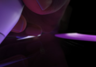 En skriveklar hånd holder en Apple Pencil Pro. Tuppen trykkes ned på skjermen og viser tykke strøk som tegnes i lilla farge.