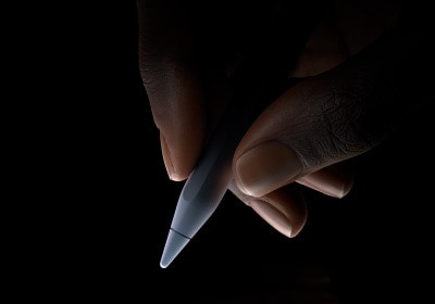 En bruker holder den nederste tredjedelen av Apple Pencil Pro mellom tommelen og pekefingeren, klar til å skrive med den.