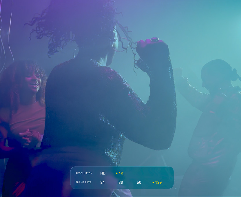 Et skærmbillede af personer, der danser under en filmoptagelse i svagt lys. Billedet viser mulighederne for optagelse i 4K med 120 billeder pr. sek. i Dolby Vision